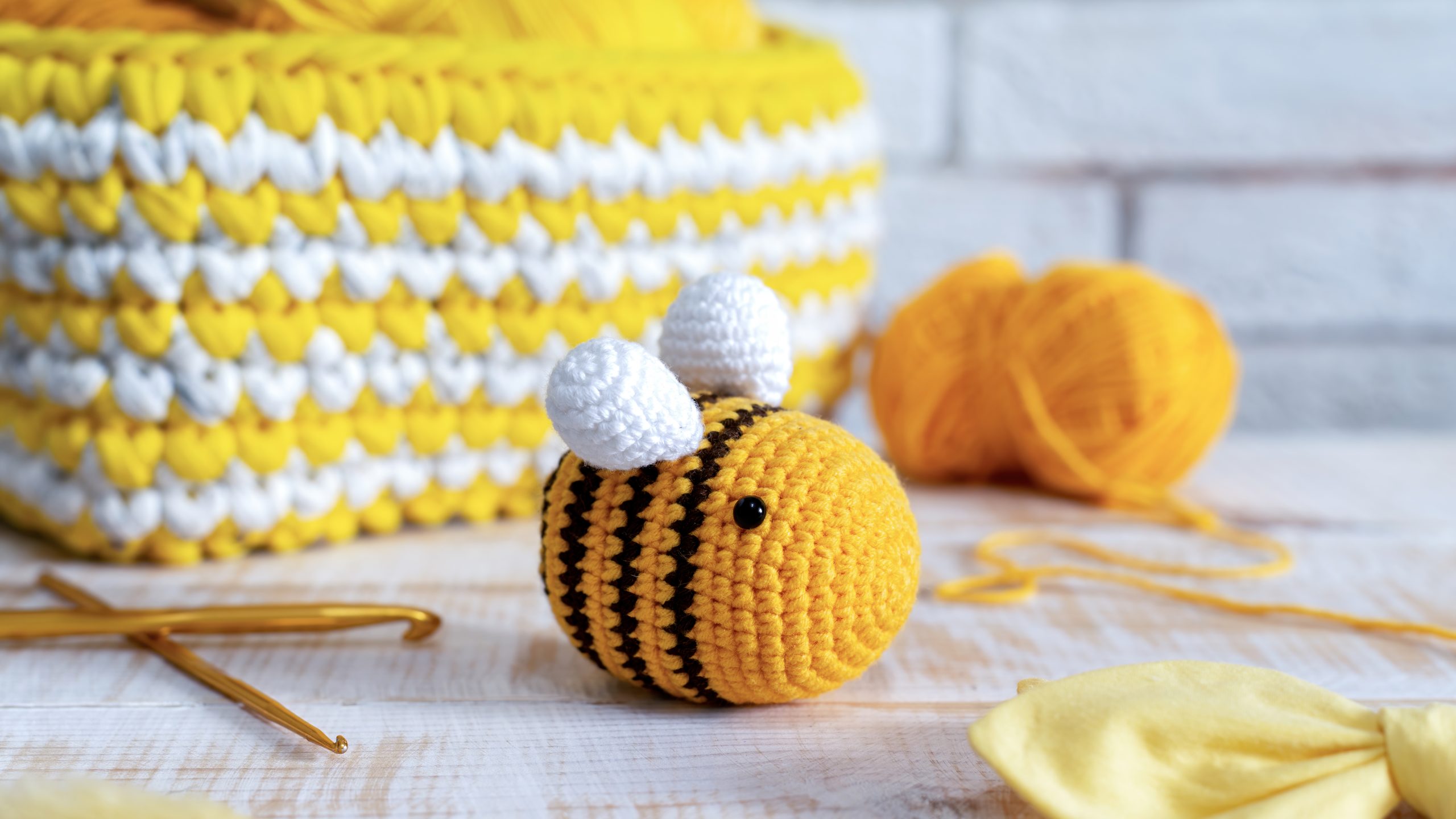 Knitted yellow bee toy on the table